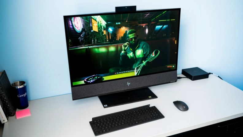An image of an HP all in one computer showing a video game on the monitor sits on a white desk.