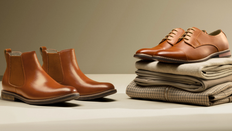 Two pairs of Bruno Marc shoes on display. The pair on the right lays on top of some neatly folded clothes.