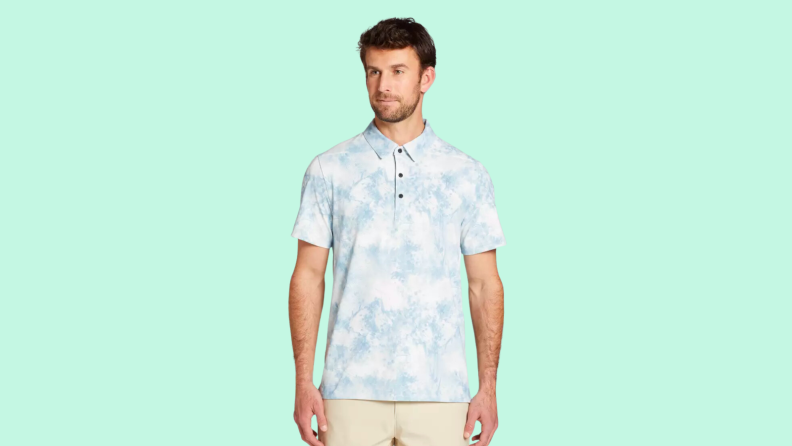 An image of a pale blue and white floral-patterned short-sleeve golf polo.