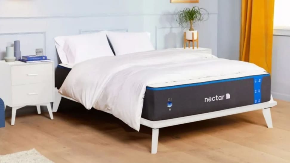 A Nectar mattress on a bed frame with bedding.