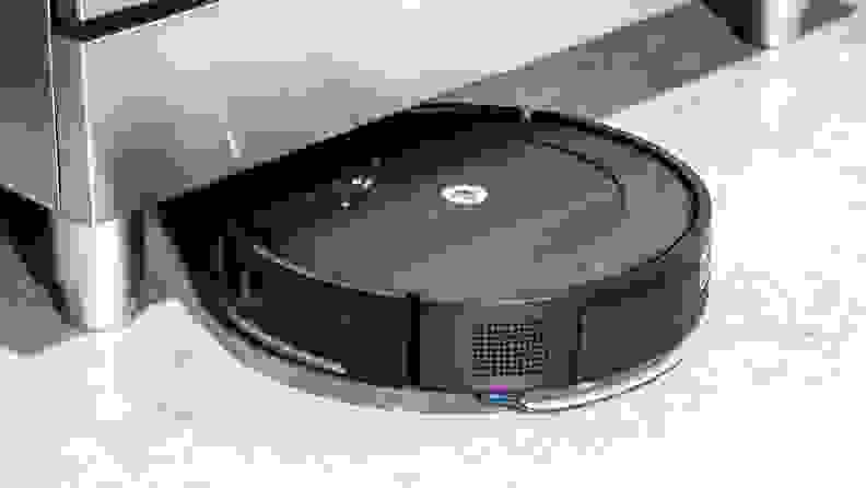 An iRobot Roomba Combo Essential emerges from under a metal object during testing for the best robot vacuums.