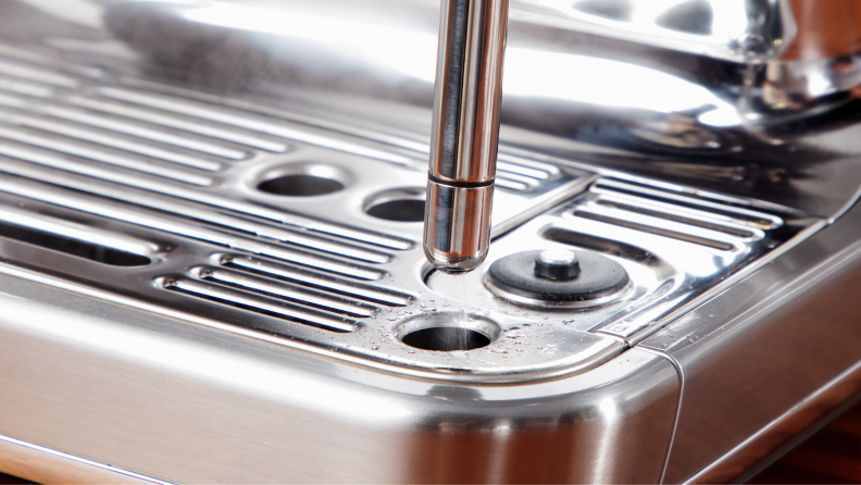 Close up shot of the automatic steam wand cleaner on the Breville Barista Touch Impress espresso machine.