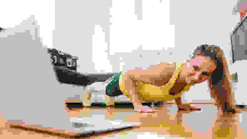 A woman taking an online yoga class.