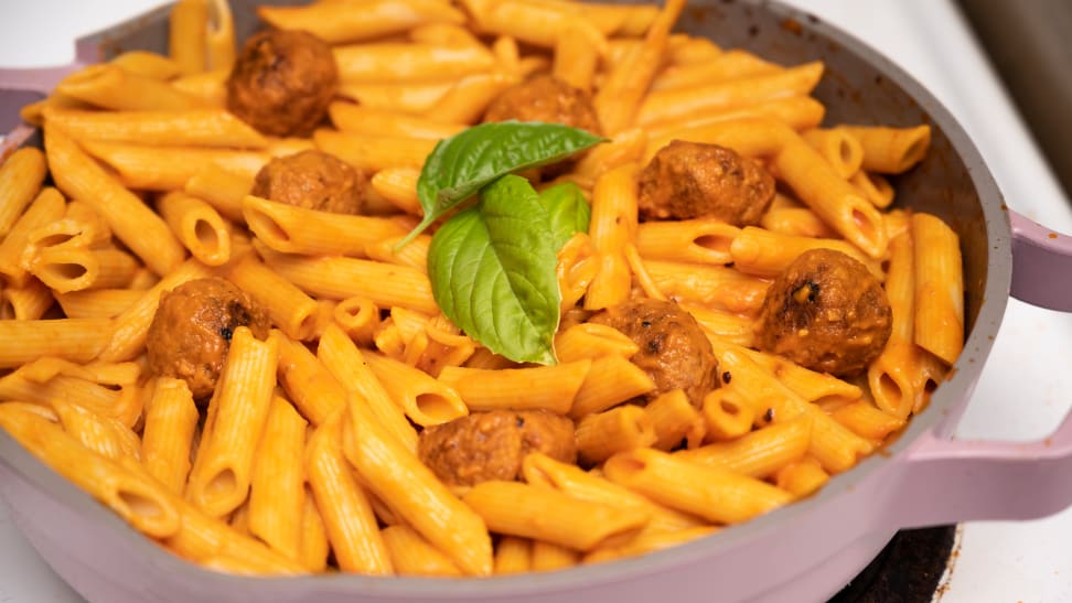 A pot of manicotti pasta cooked in tomato sauce with meatballs in an Always pan.