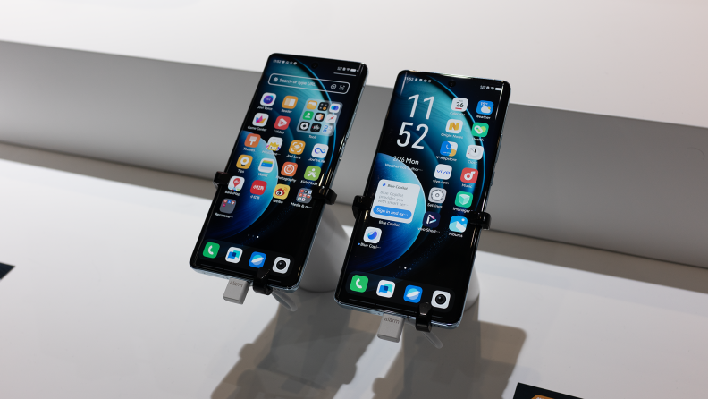 Two Vivo X100 phones sitting on displays at MWC 2024.