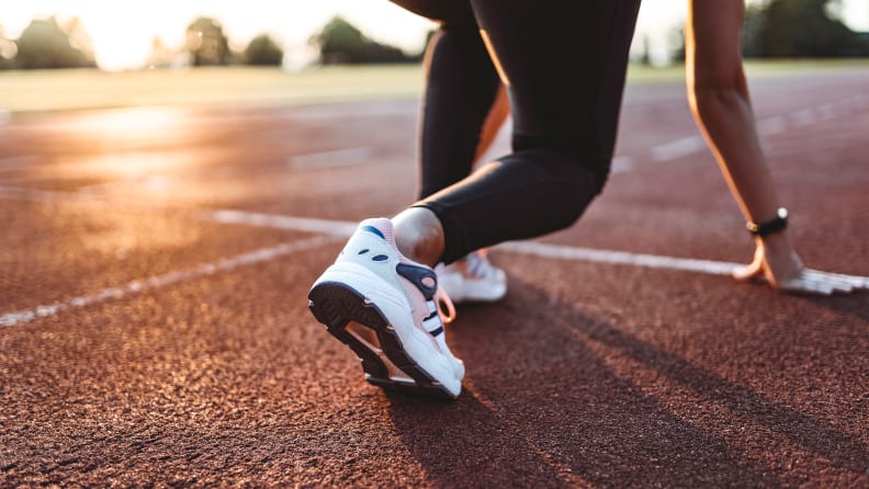 A woman lined up at a start line on a track.