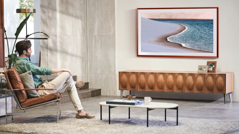 Samsung's The Frame lifestyle TV hangs on the wall in the living room setting