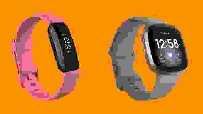 A pink and a gray Fitbit against an orange background.