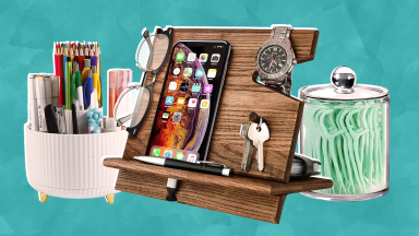 White pen organizer, wooden docking station with smartphone, a pair of glasses a set of keys on top and a clear jar with lid holding dental flossing sticks.