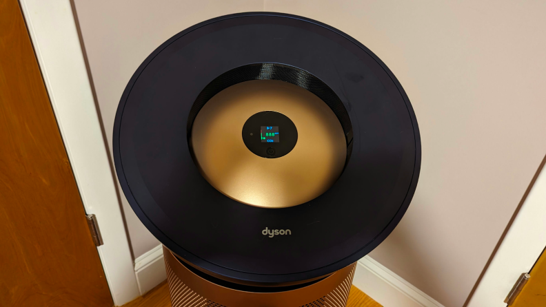 The circular form of the Dyson air purifier appears in a corner of a home.