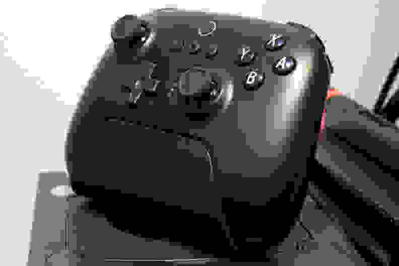A black controller sitting upright in a charging dock