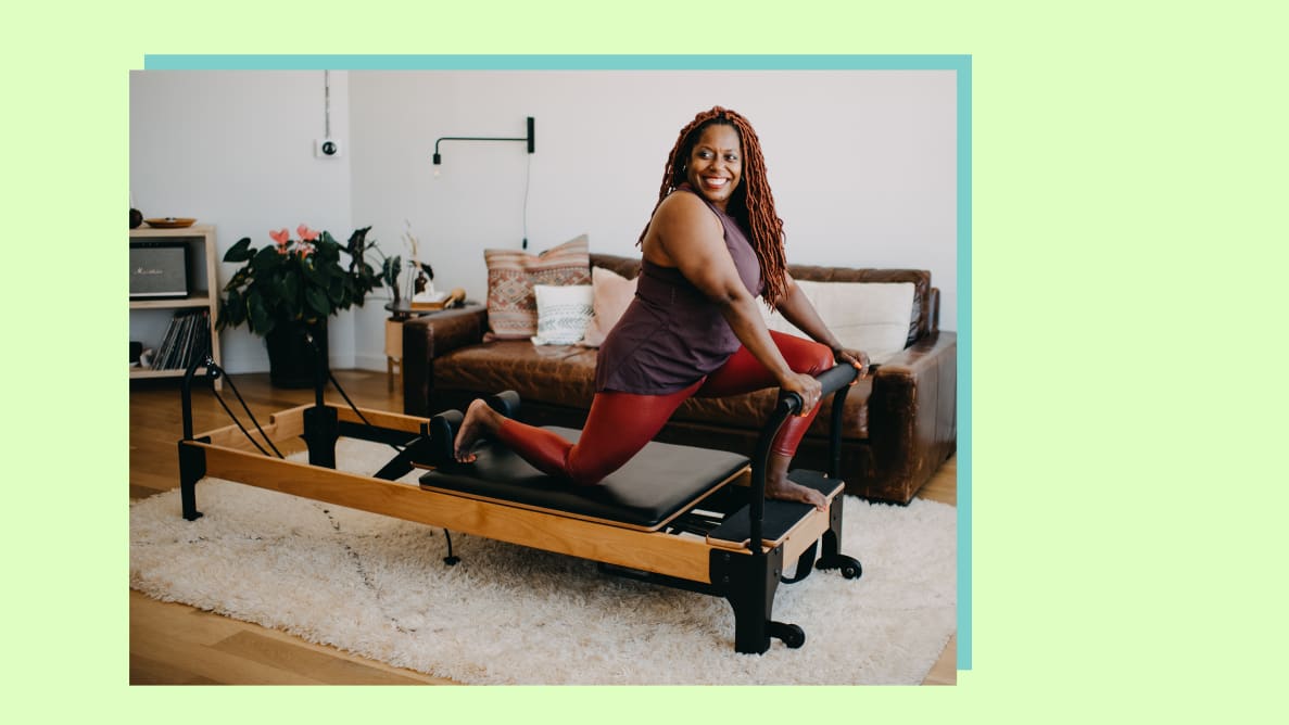 A person lunging on top of the Flexia reformer and smiling.