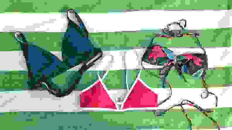 Three bikini tops lying flat on a beach towel