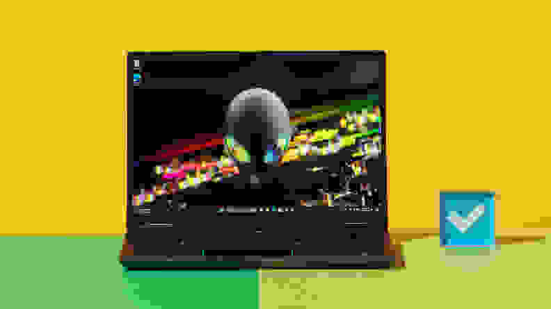 The Alienware m16 R2 gaming laptop with abstract screensaver on screen on top of a two-tone green surface.