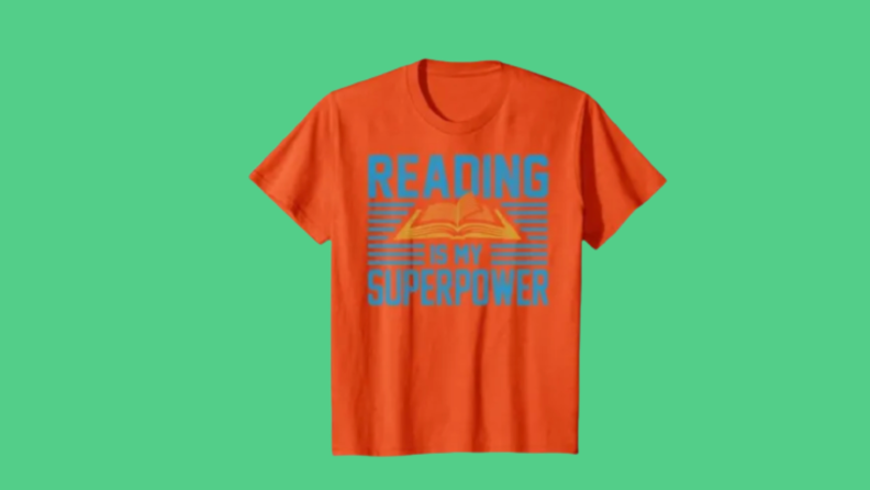 An orange shirt that says, "Reading is my superpower" with a cool open-book image.