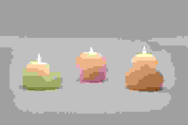 Three blob shaped candles lit up