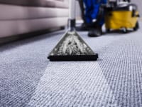 Man cleaning blue carpet