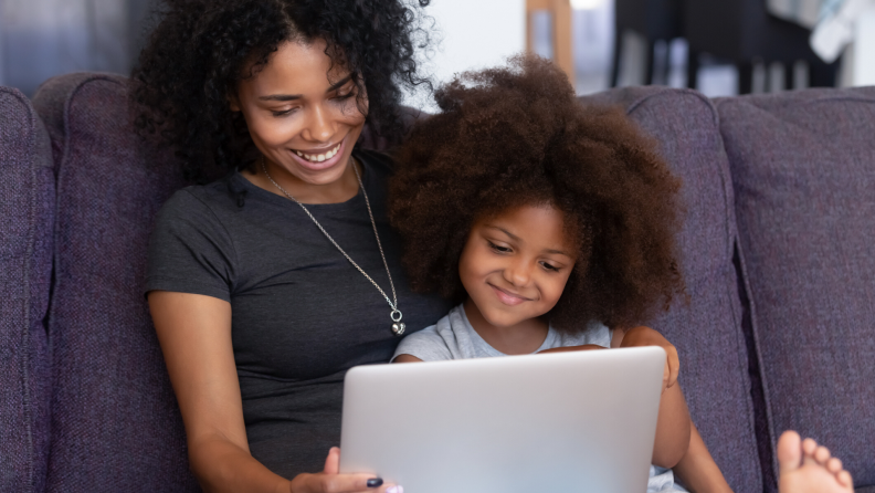 Mother and daughter watch a virtual tour on a laptop