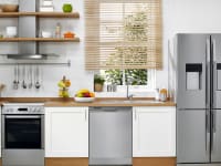 A shot of a modern kitchen filled with brand new, stainless steel appliances.