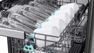 An open Samsung dishwasher with the 3rd rack pulled out to show cups and glasses, and the other 2 showing in the background.
