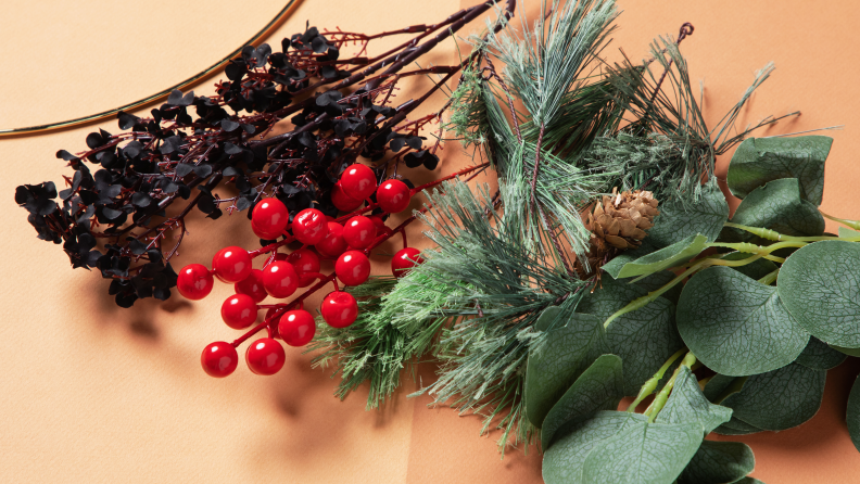 Fake red berries, pine needles, and eucalyptus bundled together.