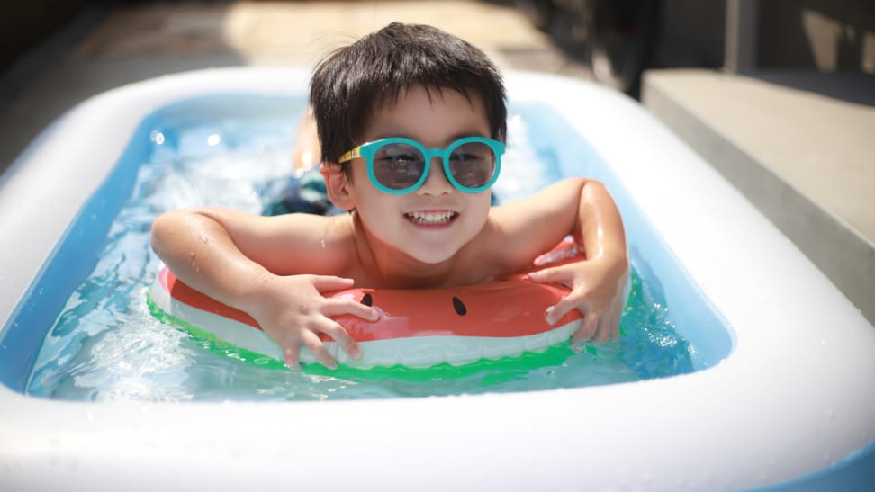 Kid riding a watermelon float in an inflatable pool