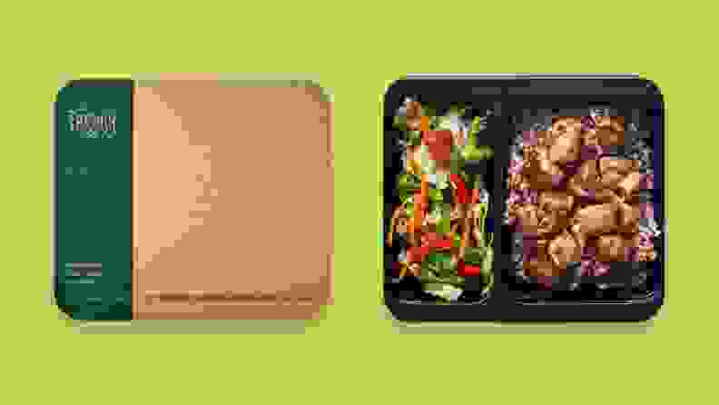 两份事先做好的微波炉晚餐并排放在绿色背景上，一份盖着盖子，另一份没有盖子，露出鸡肉和蔬菜。