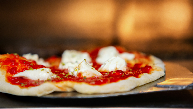 Pizza bakes in an oven.