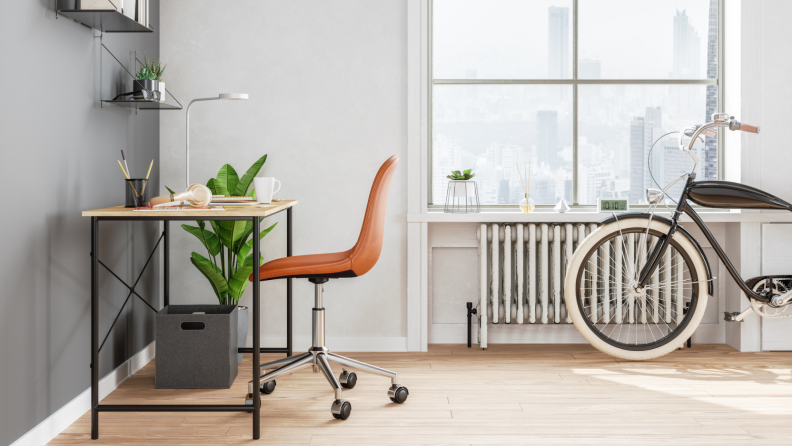 The corner of a fashionable city apartment: an artsy desk, an old-timey bicycle, incense sticks.
