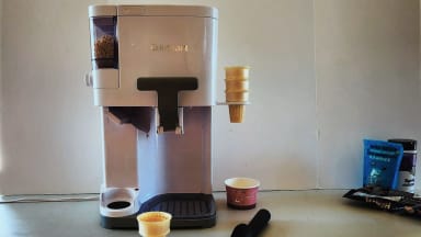 The Cuisinart Mix It In ICE-48 on a countertop surface with empty ice cream cones next to it.