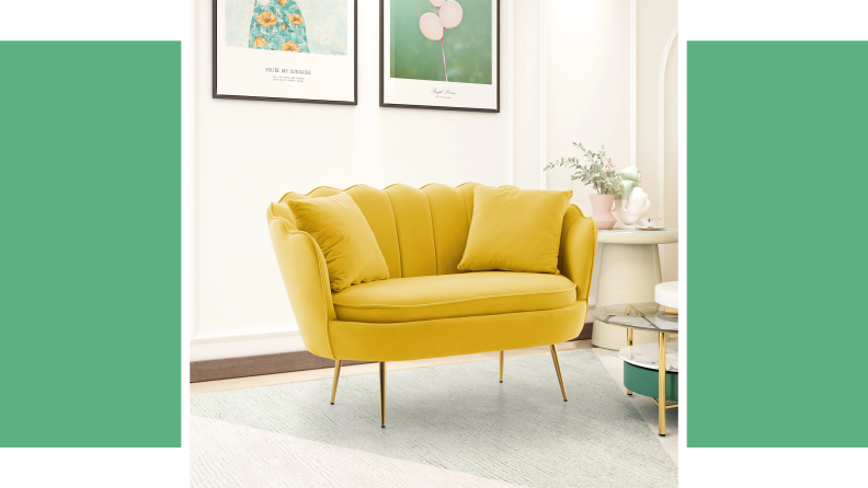 A yellow loveseat in front of a green background.