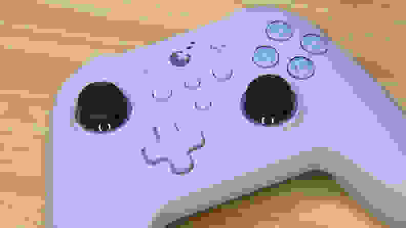 A white and purple controller on a wood table