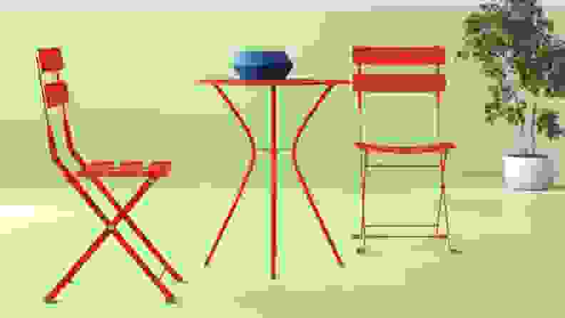 Red outdoor bistro dining set against green background.