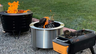 Outdoor fire pits are lined up in a yard.