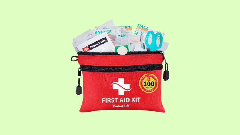 Red pouch with supplies such as bandaids and scissors coming out of the top set against a green background