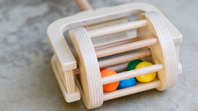 A toy mower that collects balls into a basket.