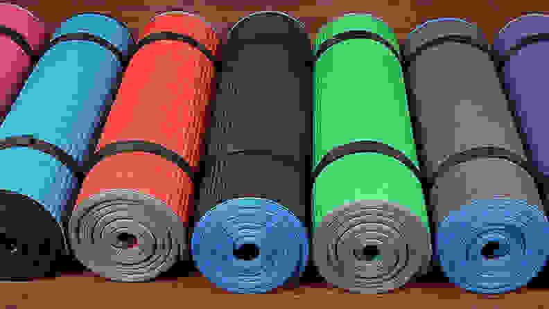An image of pilates mats rolled up on the floor.