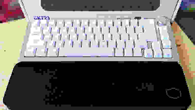 A white keyboard above a black wrist rest