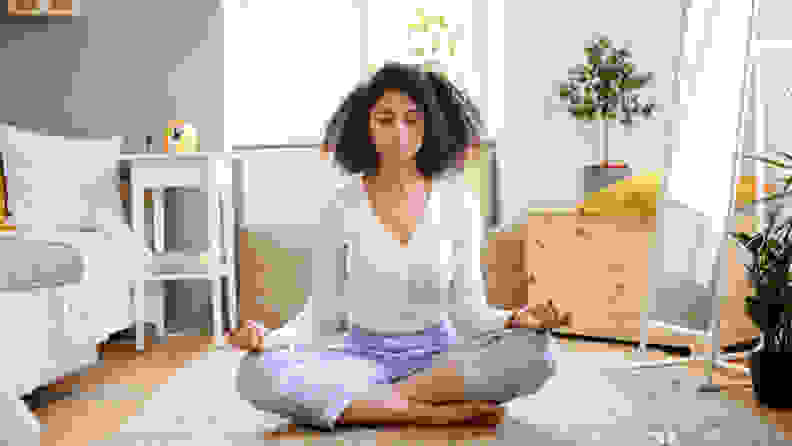 A woman meditating on the floor.