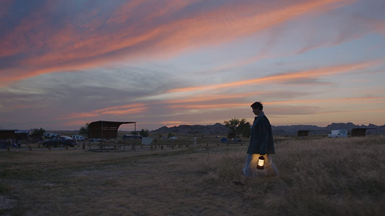 A still from the film Nomadland featuring Francis Macdormand walking across a field.