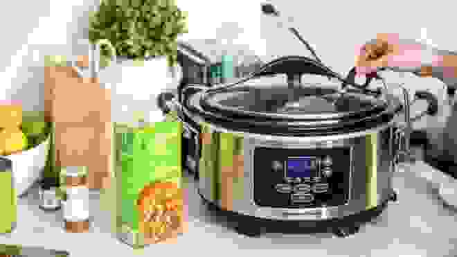 slow cooker on counter with vegetable broth next to it