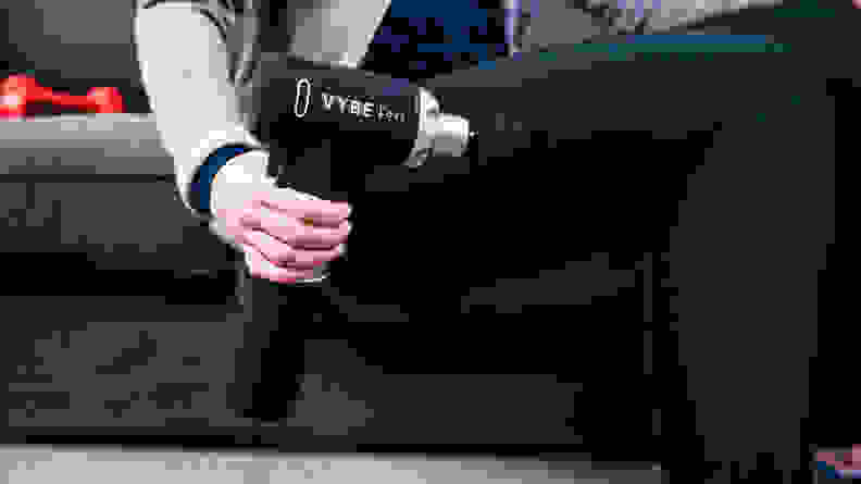 A woman using the Vybe Pro massage gun.