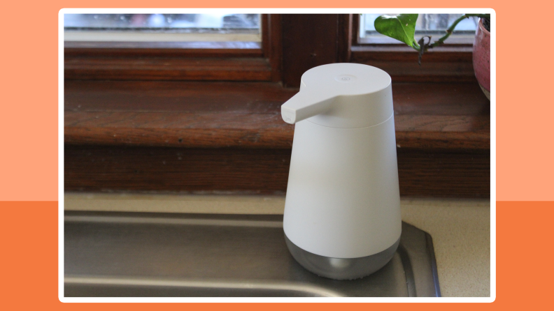 The Amazon Smart Soap Dispenser on corner of the sink in front of home window.