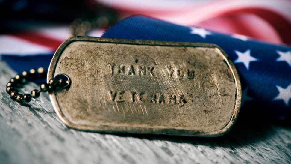 A rusted dog collar with the words "Thank you veterans" in front of a folded American flag.