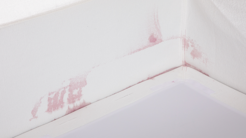 An interior view of the couch with red wine splotches all along the side.