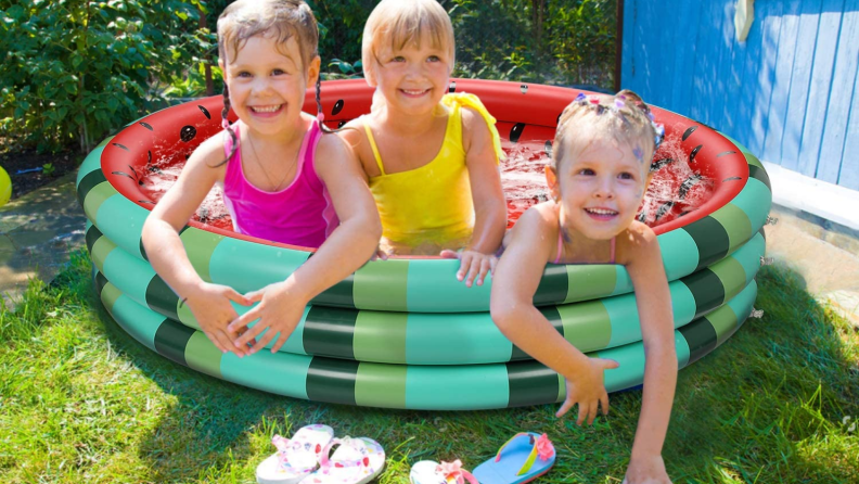 Three kids sitting in a watermelon-themed pool