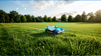 Robot lawn mower with light beams surrounding it, shown on vast grass field with blue sky and clouds.