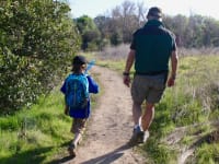 Young boy hiking with his grandfather.