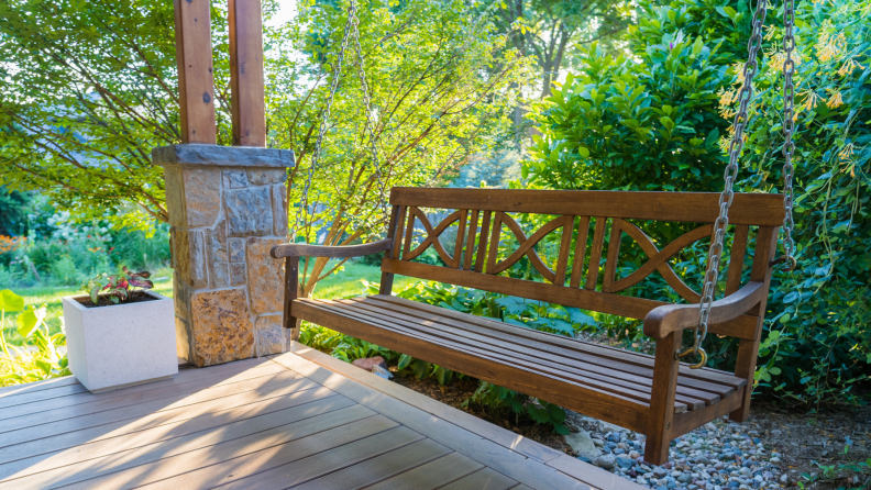 Wooden porch swing outdoors on a sunny day.