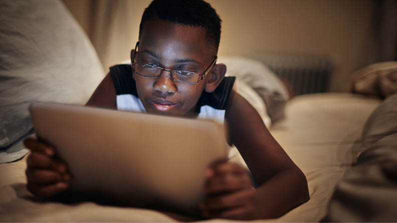 boy using a tablet on the couch